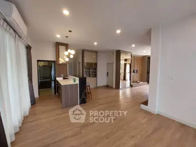 Spacious modern living room with open kitchen and elegant wooden flooring