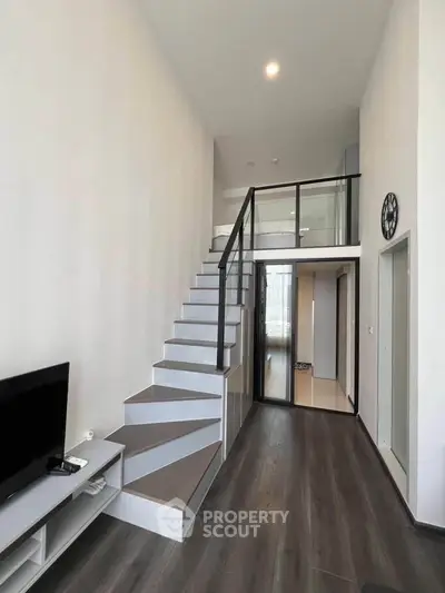 Modern duplex interior with sleek staircase and high ceilings, perfect for stylish urban living.