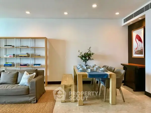 Modern living room with dining area, featuring elegant furniture and stylish decor.