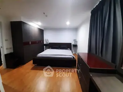 Spacious modern bedroom with sleek furniture and wooden flooring