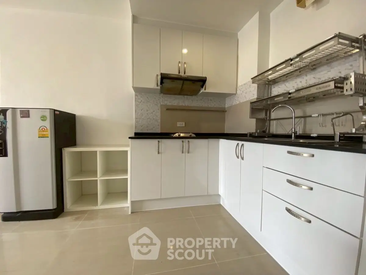 Modern kitchen with sleek white cabinets and stainless steel appliances
