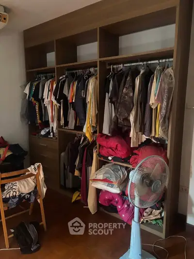 Spacious bedroom with wooden wardrobe and organized clothing storage