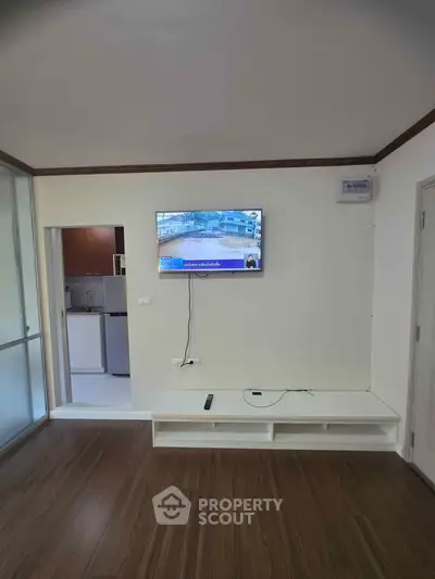 Modern living room with wall-mounted TV and sleek wooden flooring