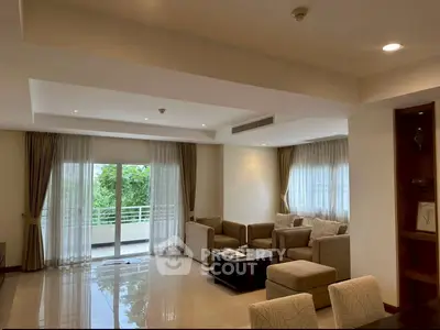 Spacious living room with elegant furniture and large windows offering natural light.