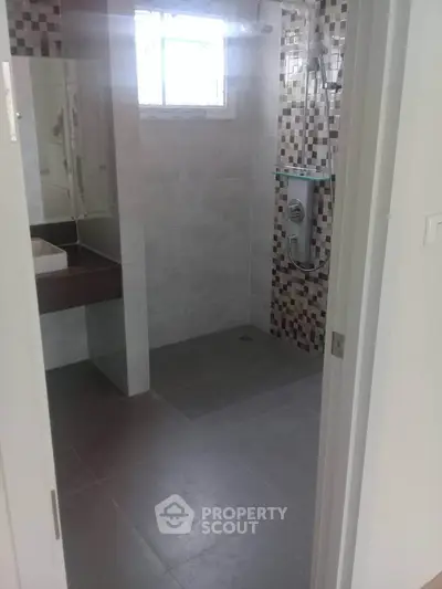 Modern bathroom with tiled walls and glass shower enclosure