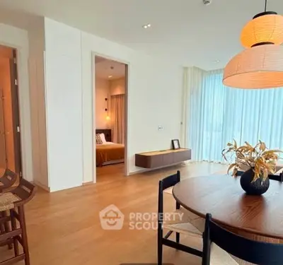 Spacious modern living room with dining area and view into cozy bedroom