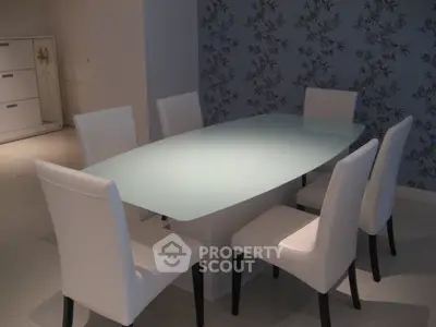 Elegant dining area with modern glass table and stylish white chairs