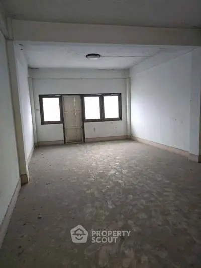 Spacious empty room with large windows and natural light, ideal for customization.
