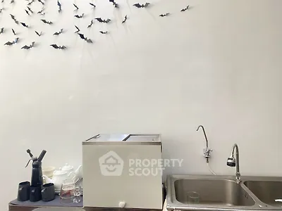 Modern kitchen with sleek sink and minimalist decor, featuring unique wall art of flying bats.