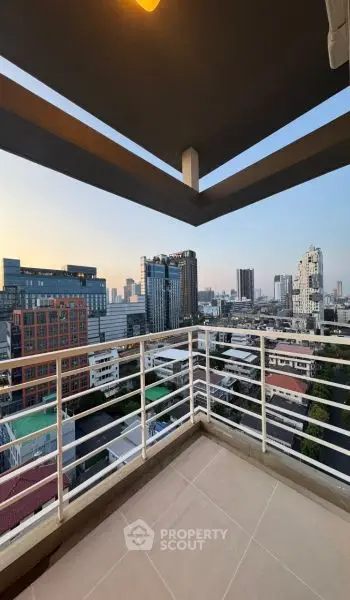 Stunning cityscape view from a modern balcony in a high-rise building at sunset.