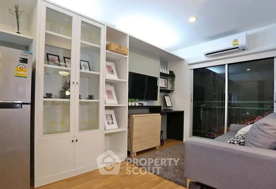 Modern living room with sleek furniture and city view balcony in a stylish apartment.