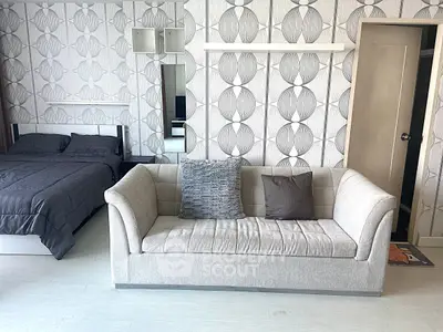 Modern studio apartment with stylish wallpaper and cozy sofa, perfect for urban living.