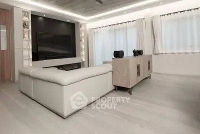 Modern living room with sleek design, featuring a large TV and comfortable seating.
