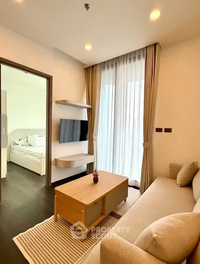 Modern living room with cozy sofa, wall-mounted TV, and large window with curtains.