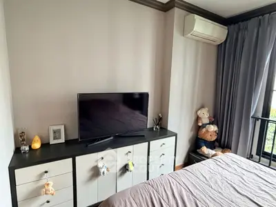 Cozy bedroom with modern TV setup and plush toys, perfect for relaxation.