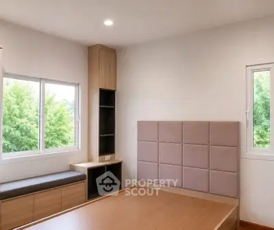 Modern minimalist bedroom with large windows and built-in storage, offering a serene view of lush greenery.