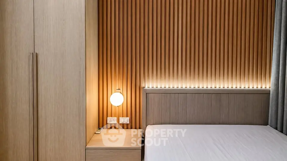 Modern bedroom with sleek wooden paneling and ambient lighting