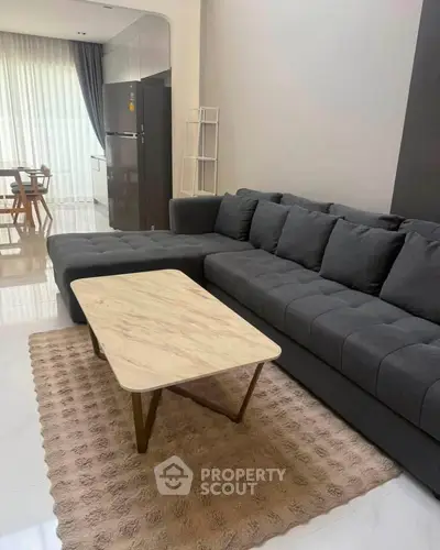 Modern living room with stylish gray sectional sofa and elegant marble coffee table