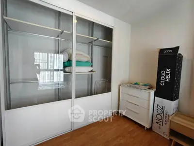 Spacious bedroom with sleek sliding wardrobe and modern dresser, perfect for stylish storage solutions.