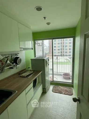 Bright and airy kitchen with modern appliances, ample cabinet space, and a charming balcony with urban views, perfect for culinary enthusiasts.