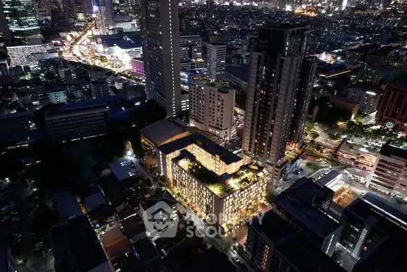 Stunning aerial view of illuminated cityscape showcasing modern high-rise buildings at night.