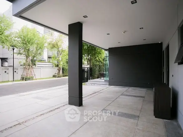 Modern building entrance with sleek design and spacious outdoor area.