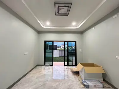 Spacious modern living room with large sliding glass doors and elegant ceiling design.