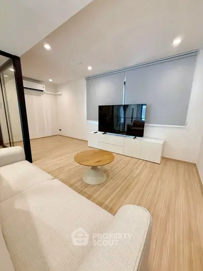 Modern living room with sleek TV setup and cozy sofa