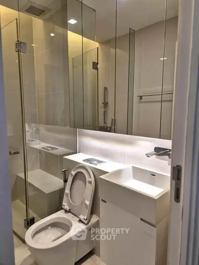 Modern bathroom with glass shower and sleek fixtures in a contemporary apartment.