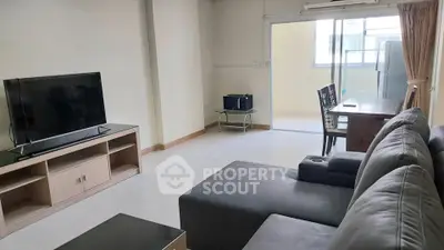 Spacious living room with modern furniture and large TV, perfect for relaxation and entertainment.