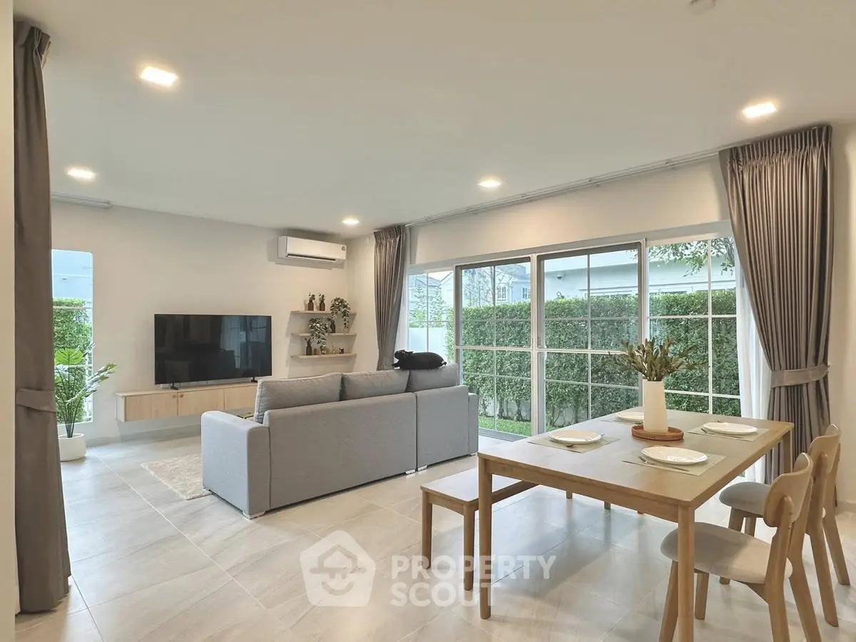 Spacious modern living room with large windows and elegant dining area