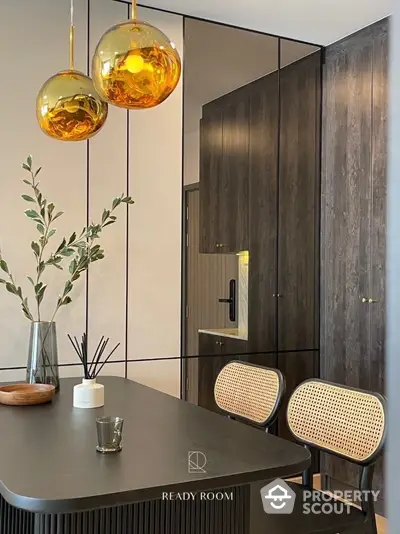 Elegant entryway with chic black wooden door and stylish dark furniture complemented by golden pendant lights and modern decor.