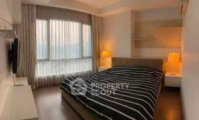 Cozy bedroom with large window and modern decor in a stylish apartment.