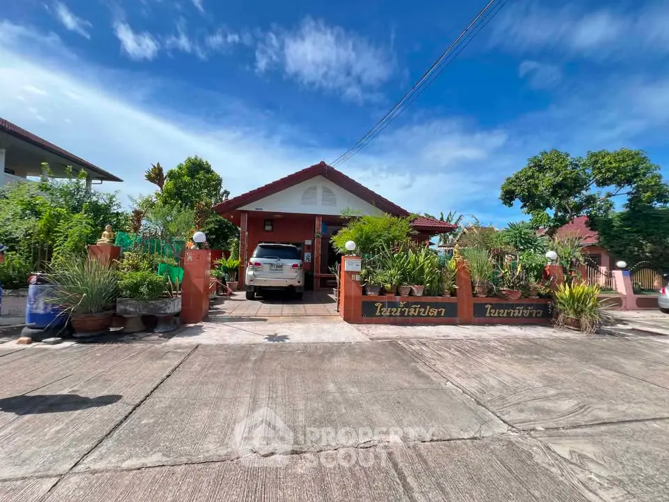 Charming suburban home with lush garden and spacious driveway under a clear blue sky.