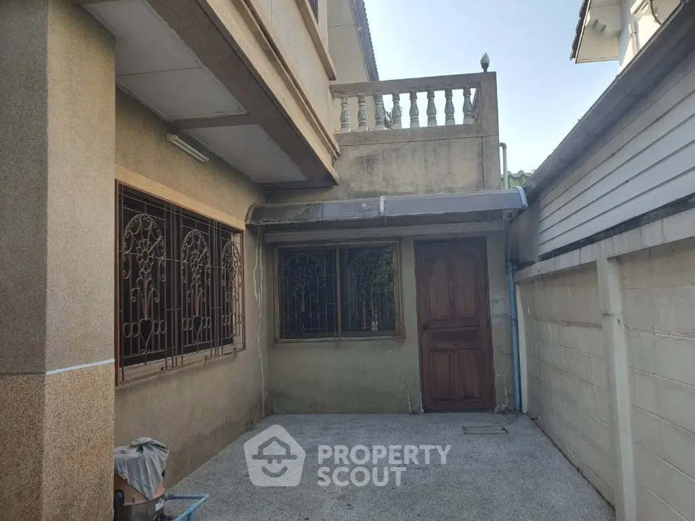 Charming exterior view of a classic home with ornate window grills and spacious patio area.