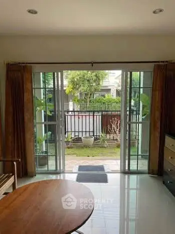 Bright living room with sliding glass doors leading to a garden view.