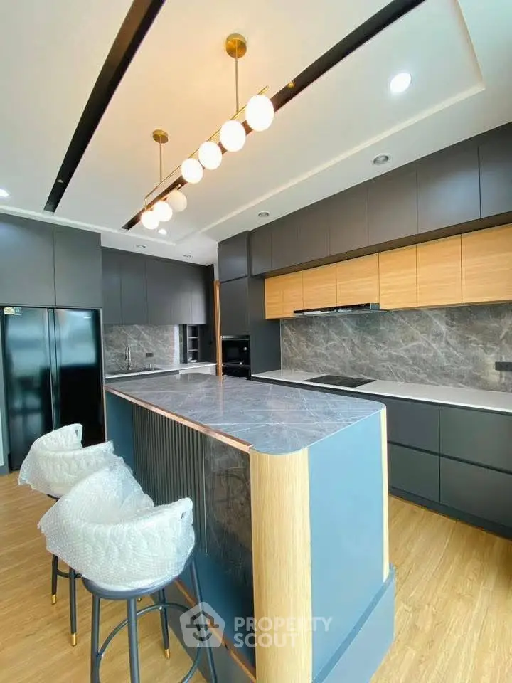 Modern kitchen with sleek cabinetry, marble countertops, and stylish lighting fixtures.