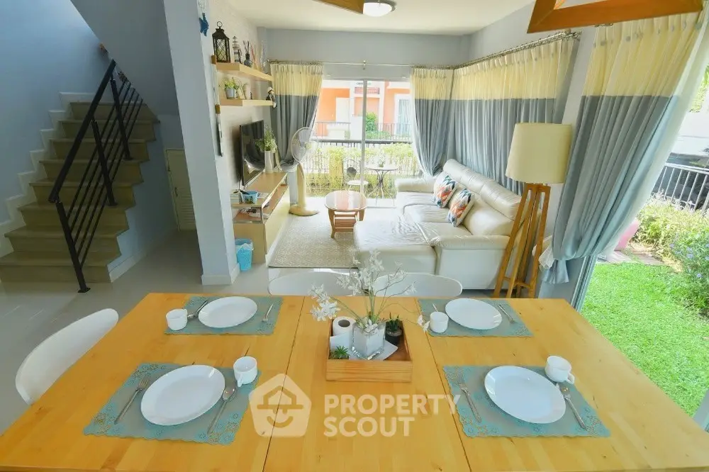 Spacious living room with garden view, elegant dining setup, and modern decor