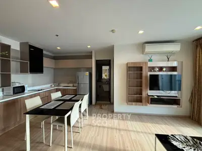 Modern open-plan kitchen and living area with sleek furniture and natural light.