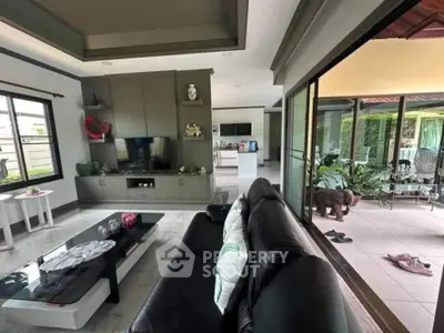 Spacious modern living room with sliding doors to a lush garden patio, perfect for relaxation.