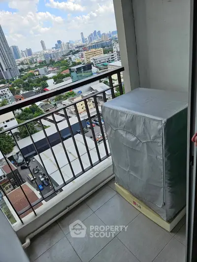 High-rise balcony with cityscape view and covered appliance, ideal for urban living.