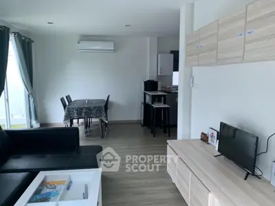 Modern living room with sleek furniture and open layout, featuring a cozy dining area and stylish decor.