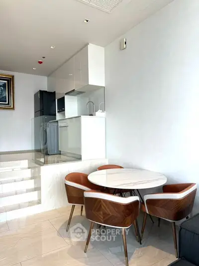 Modern open-layout kitchen with stylish dining area and sleek appliances in a bright, contemporary apartment.