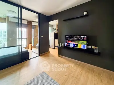 Modern living room with sleek design and open layout, featuring a wall-mounted TV and glass partition.