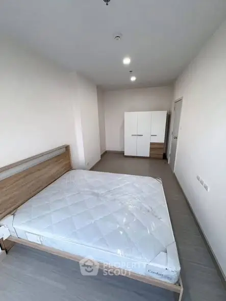 Spacious bedroom with modern design and ample natural light, featuring a comfortable bed and sleek wardrobe.