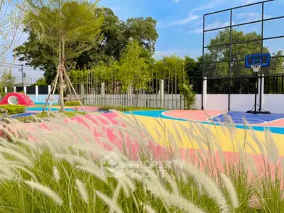 Vibrant outdoor basketball court with lush greenery and colorful play area, perfect for active living.