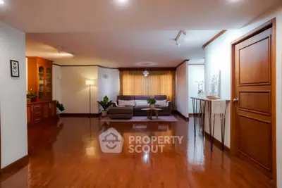 Spacious living room with polished wooden floors and elegant decor