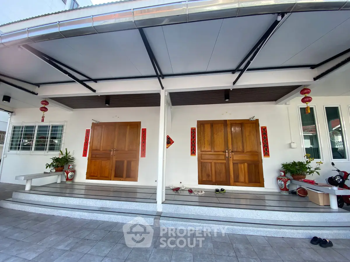 Charming dual-entry home with traditional wooden doors and decorative lanterns.