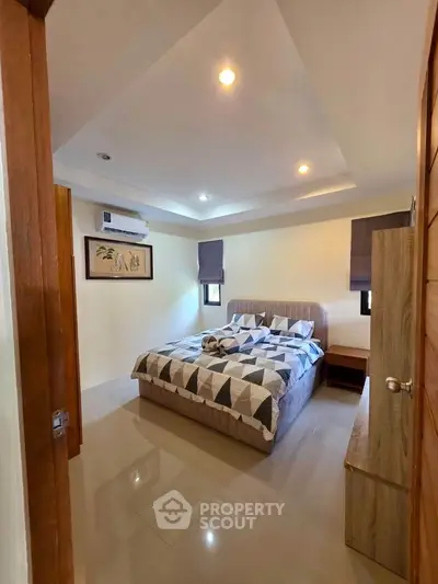 Cozy bedroom with modern decor and ample natural light, featuring a stylish bed and elegant furnishings.