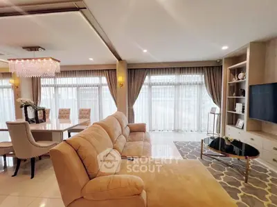 Luxurious living room with elegant chandelier and plush sofa in modern open-plan design.